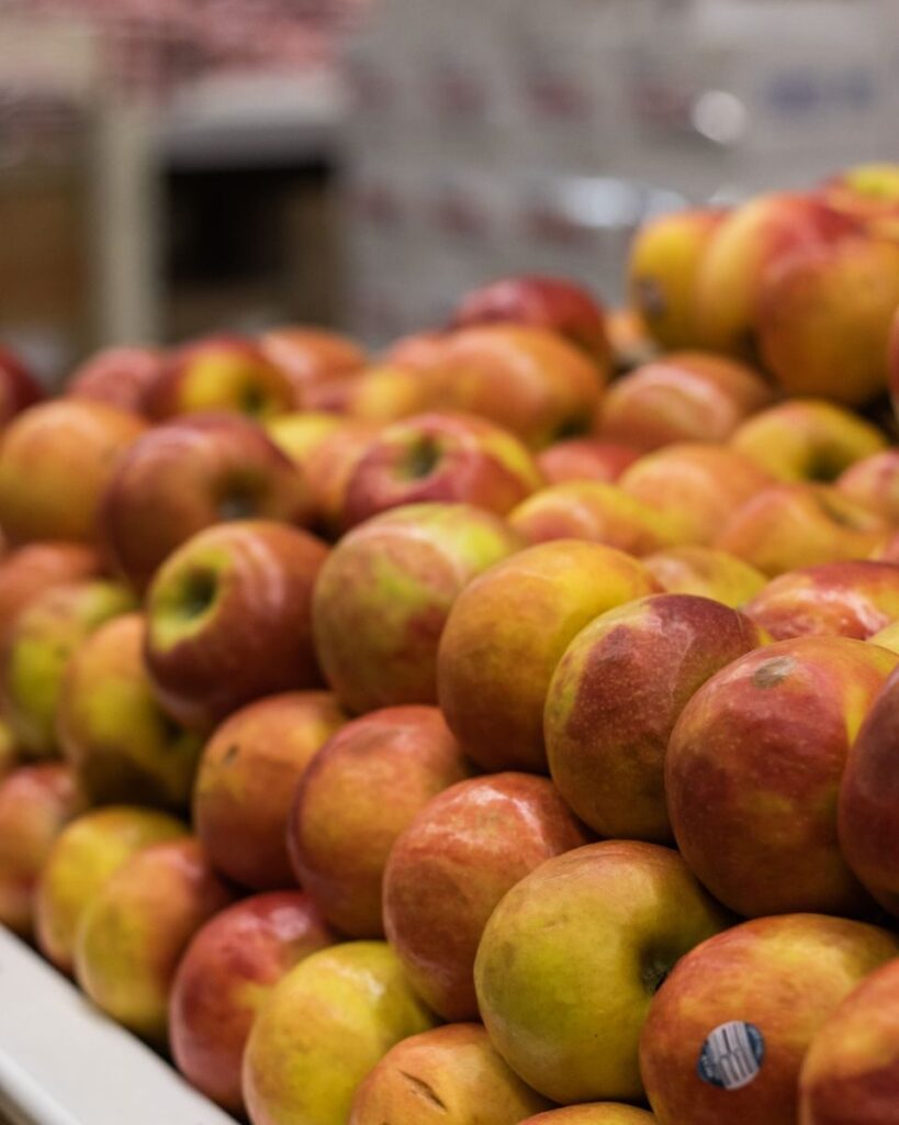 A vibrant display of fresh red apples at a market stall, showcasing natural health and nutrition.